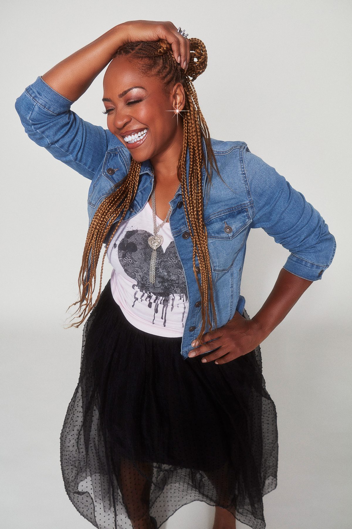 Close headshot of Divine Brown against a dark backdrop